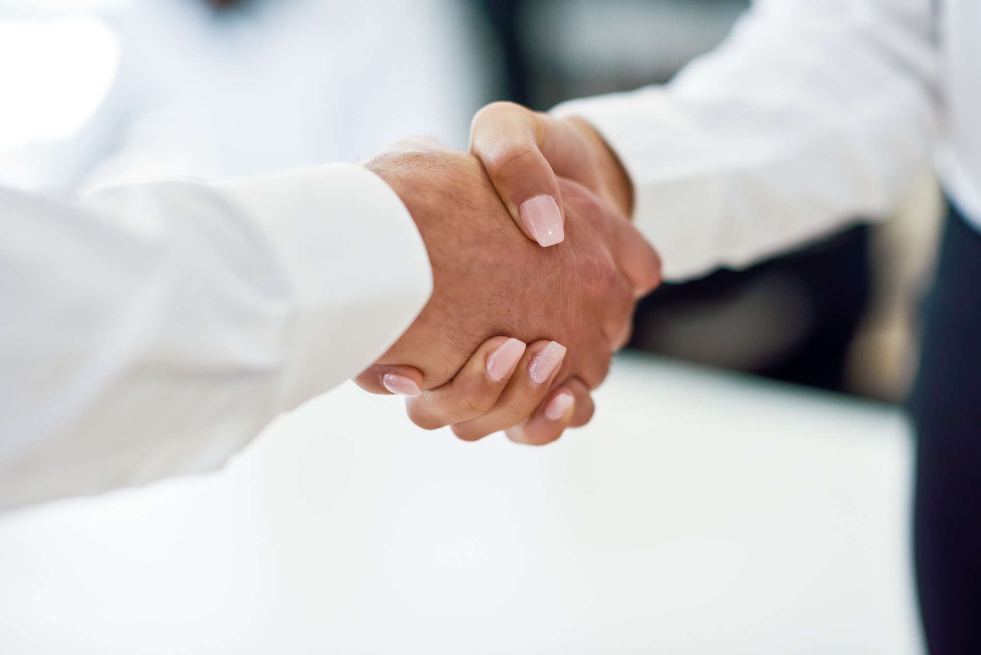 Caucasian businessman shaking hands with businesswoman in an off